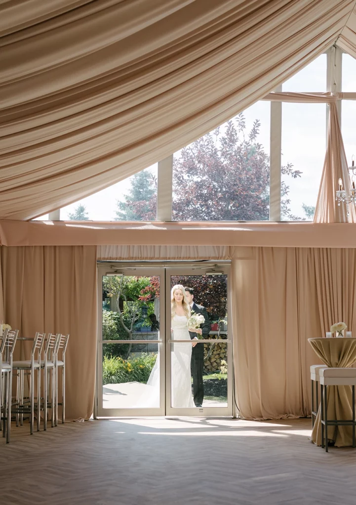 Glass door installation on event tent with a bride and groom walking through it
