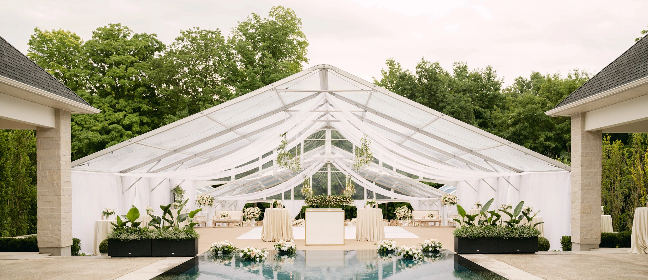 Tent rental for a large outdoor event with beautiful floral arrangements
