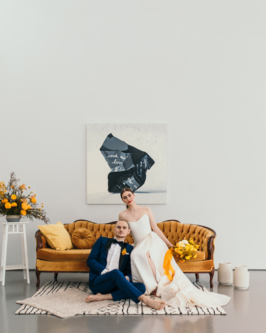 Bride and Groom sitting on a yellow vintage sofa